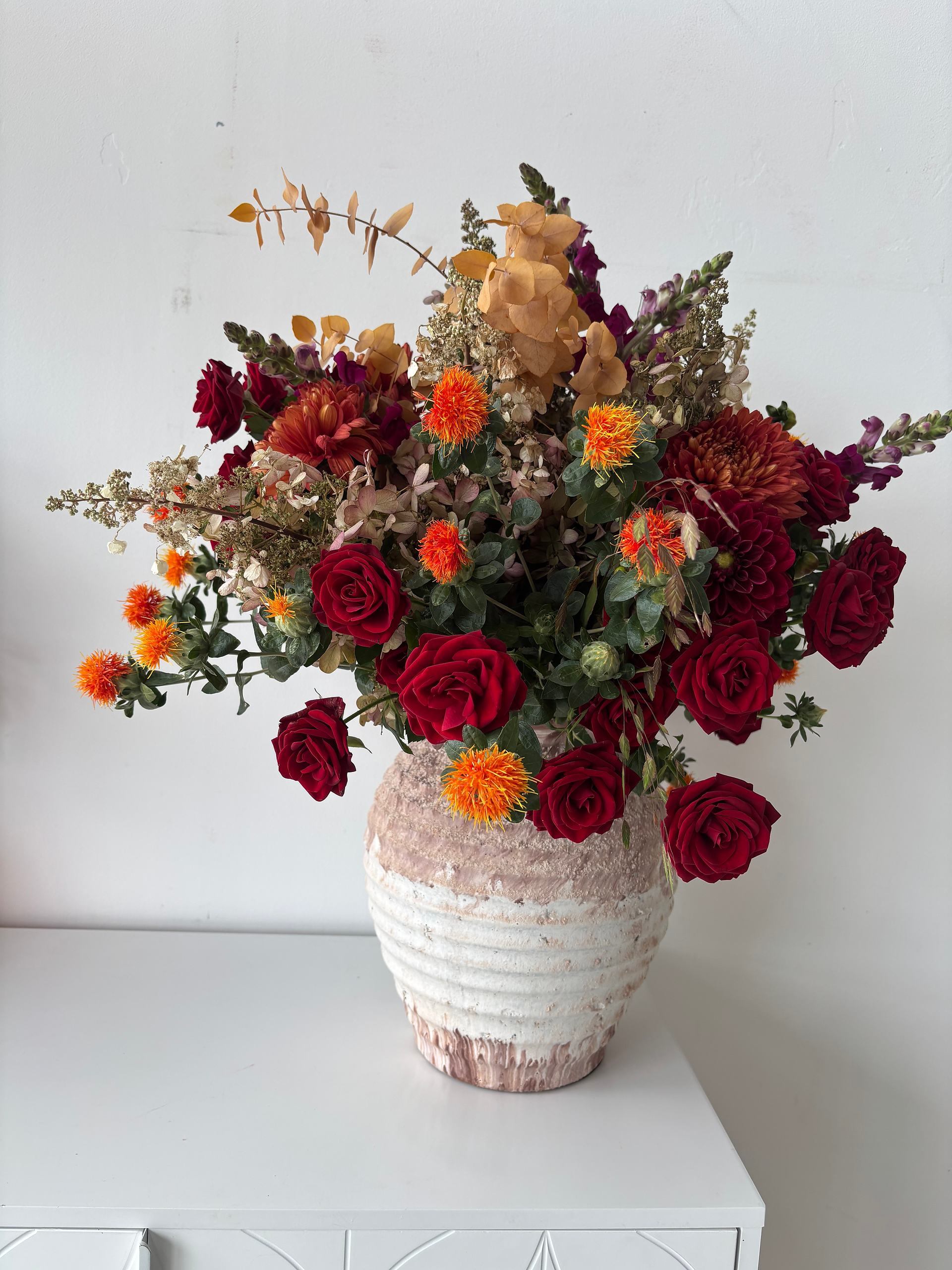 Autumn trend design autumn coloured flowers in a terracotta vase 